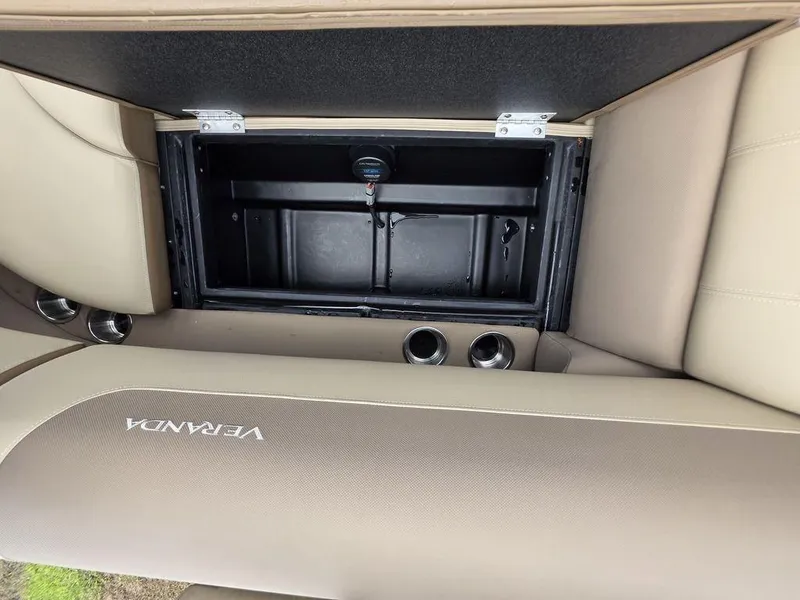 Slide: The Image of 2025 Veranda VR22RC XL Tri-Toon storage compartment with beige seating and cup holders. - 43