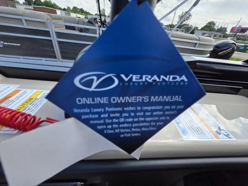 Slide: The Image of 2025 Veranda VR22RC XL Tri-Toon online owner's manual tag on boat dashboard. - 46