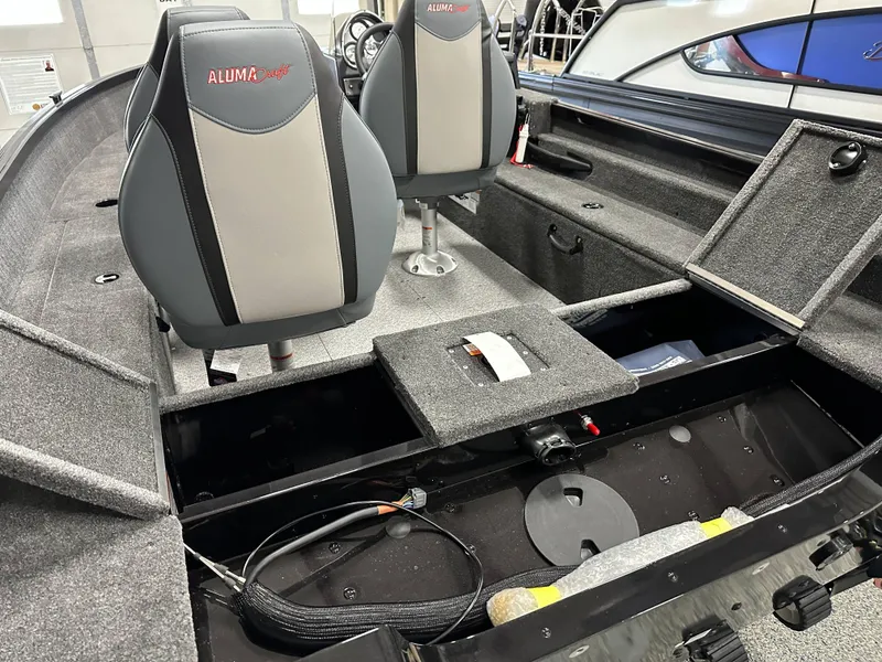 Slide: The Image of 2024 Alumacraft Classic 165 SC boat interior with storage compartments and seating. - 13