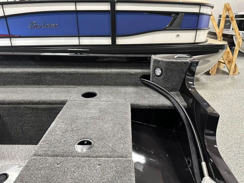 Slide: The Image of 2024 Alumacraft Classic 165 SC interior with gray carpet and storage compartments. - 14