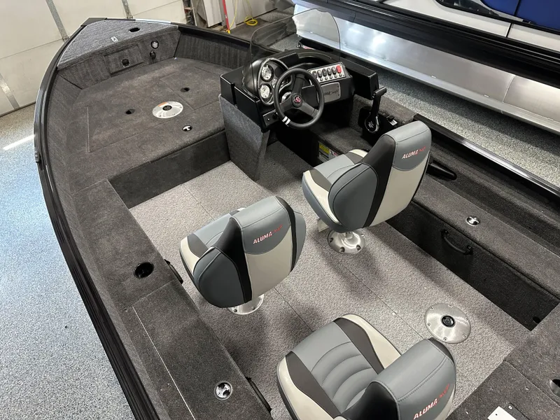 Slide: The Image of 2024 Alumacraft Classic 165 SC boat interior with dual seats and steering console. - 2