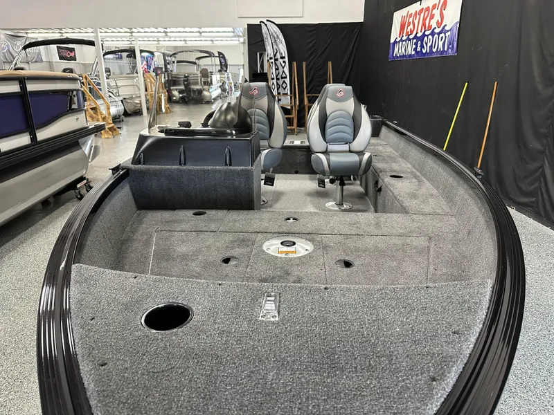 Slide: The Image of 2024 Alumacraft Classic 165 SC boat interior with seating and storage, displayed at a marine showroom. - 4