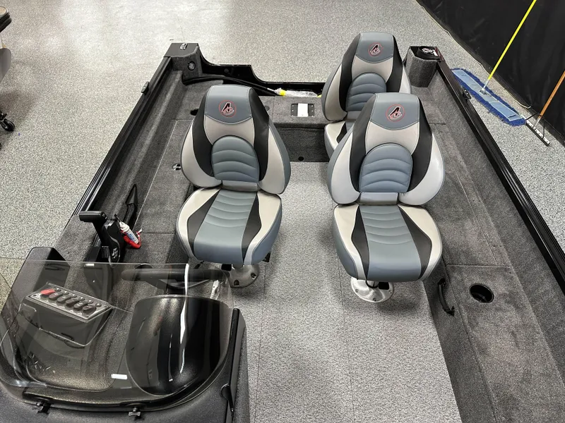 Slide: The Image of 2024 Alumacraft Classic 165 SC interior with gray and black seating, steering console, and carpeted flooring. - 9
