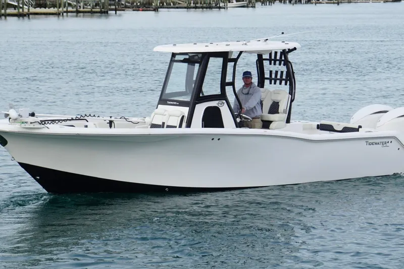 Slide: The Image of 2024 Tidewater 292 CC Adventure boat cruising on calm water. - 0