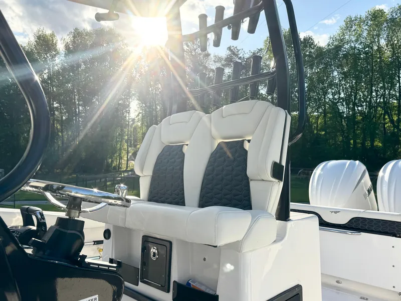 Slide: The Image of 2024 Tidewater 292 CC Adventure boat interior with dual seats, steering wheel, and sunlight. - 15