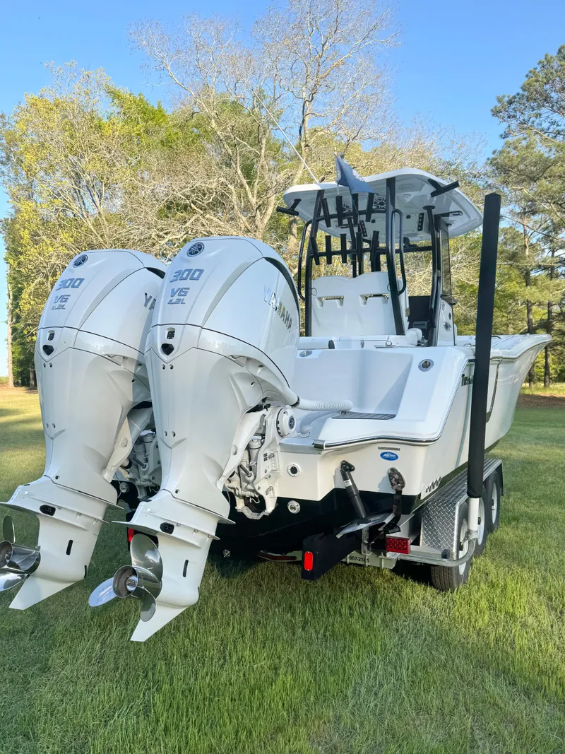 Slide: The Image of 2024 Tidewater 292 CC Adventure boat with dual engines, parked on grass. - 9