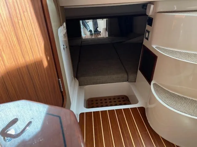 Slide: The Image of 2019 Grady-White Express 330 cabin interior with wood flooring and cozy sleeping area. - 11