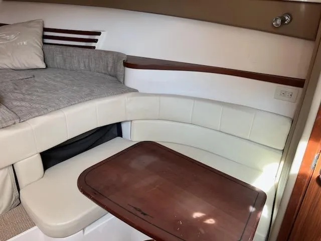 Slide: The Image of 2019 Grady-White Express 330 cabin interior with seating and wooden table. - 12