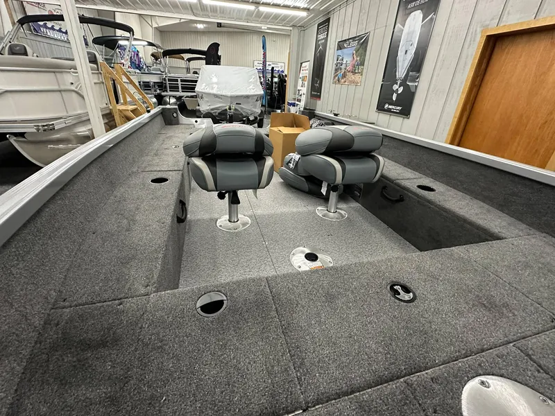 Slide: The Image of 2024 Alumacraft Classic 165 Tiller boat interior with seating and storage compartments. - 10