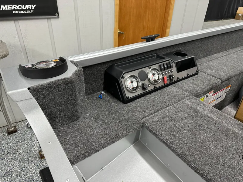 Slide: The Image of 2024 Alumacraft Classic 165 Tiller interior with dashboard and seating, showcasing carpeted flooring. - 14