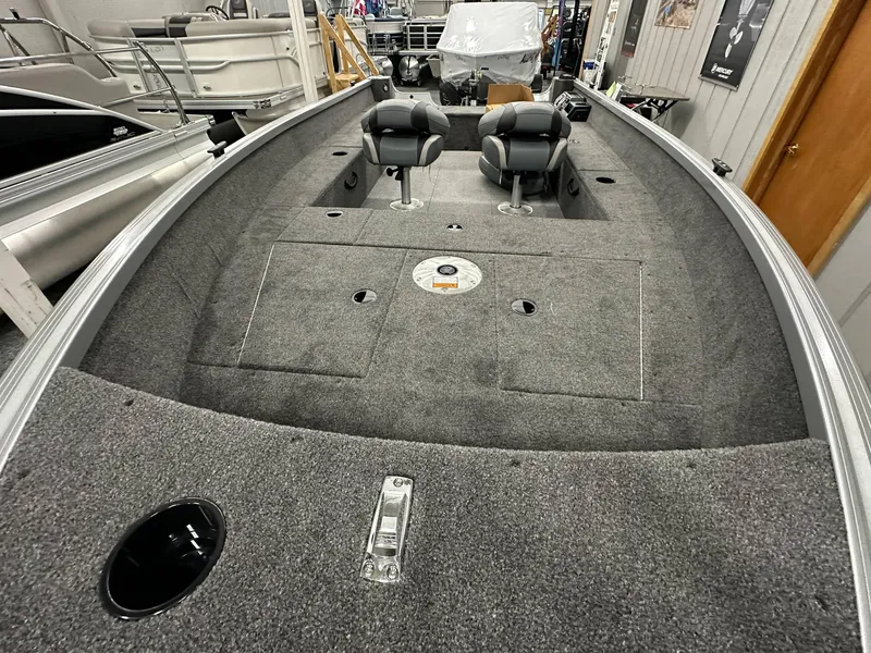 Slide: The Image of 2024 Alumacraft Classic 165 Tiller boat interior with gray carpet and seating. - 5