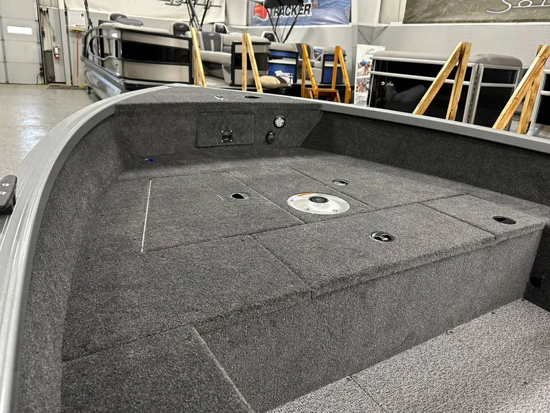 Slide: The Image of 2024 Alumacraft Classic 165 Tiller boat interior with carpeted deck in showroom. - 7