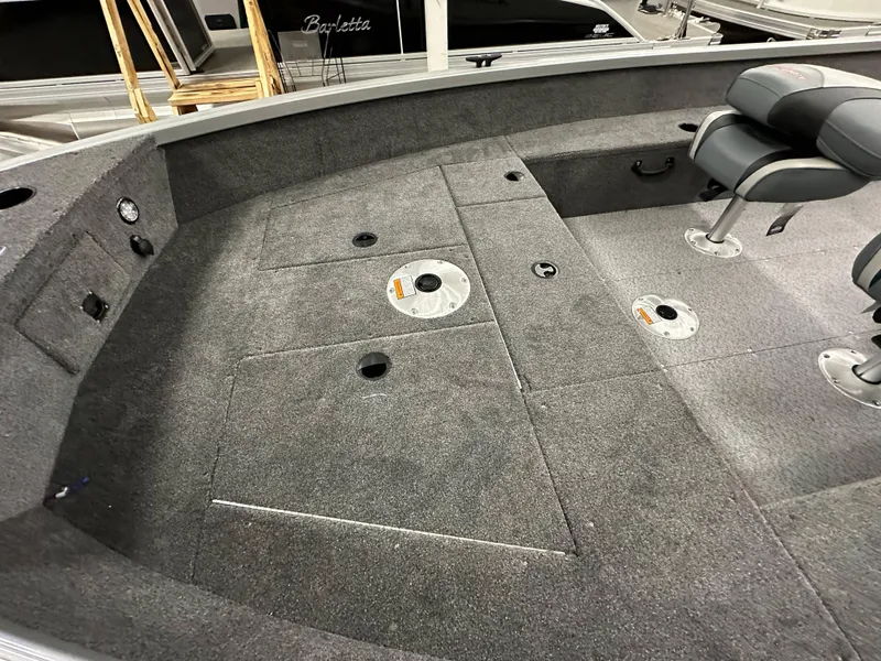 Slide: The Image of 2024 Alumacraft Classic 165 Tiller interior with carpeted deck and seating. - 9