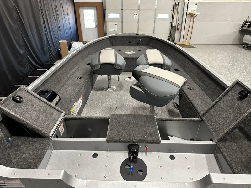 Slide: The Image of 2024 Alumacraft Classic 165 Tiller boat interior with seating and storage compartments. - 12