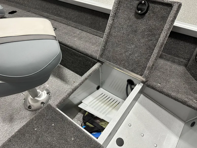 Slide: The Image of 2024 Alumacraft Classic 165 Tiller boat interior with open storage compartment and seat. - 14