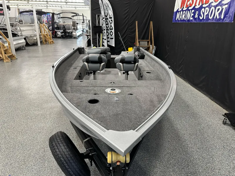 Slide: The Image of 2024 Alumacraft Classic 165 Tiller boat displayed in showroom, featuring spacious interior and seating. - 5