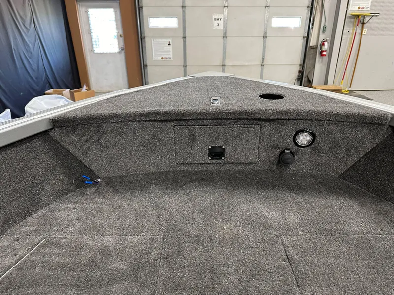 Slide: The Image of 2024 Alumacraft Classic 165 Tiller boat interior with carpeted deck and storage compartments. - 7