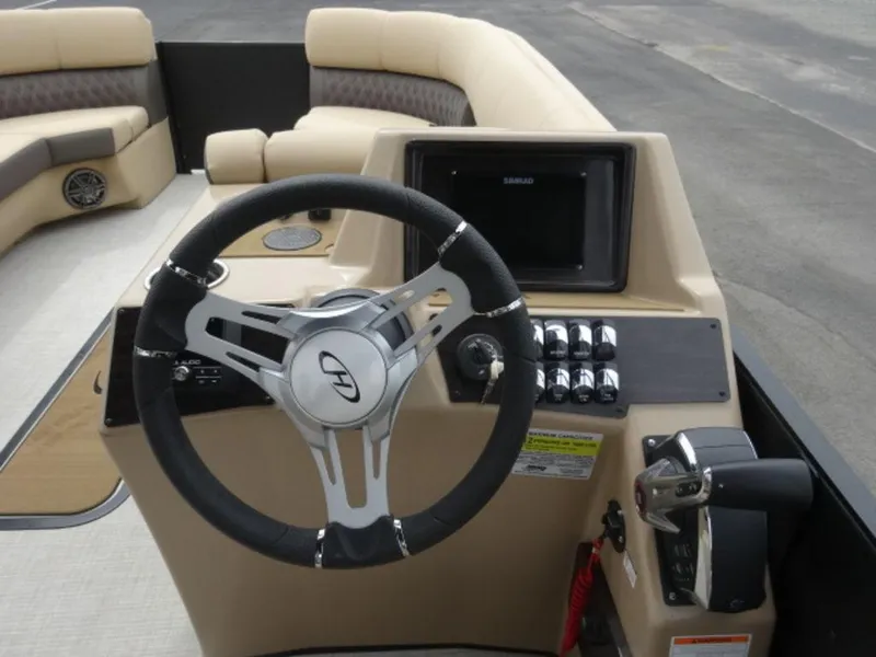 Slide: The Image of 2023 Harris Sunliner 230 boat dashboard with steering wheel and control panel. - 13