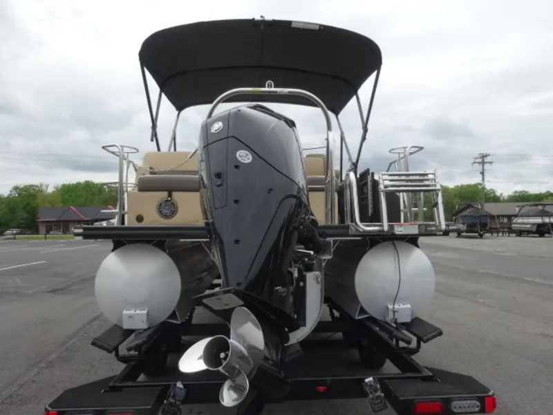 Slide: The Image of 2023 Harris Sunliner 230 pontoon boat with outboard motor, parked on a trailer. - 19
