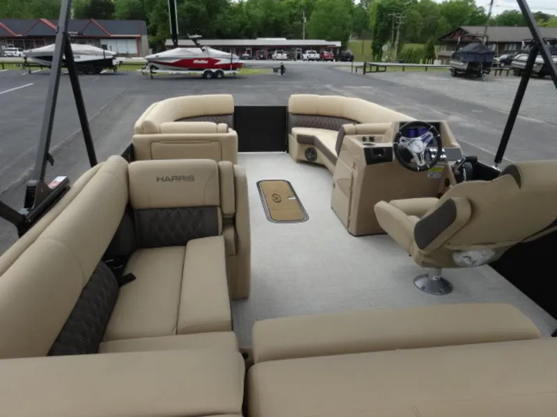 Slide: The Image of 2023 Harris Sunliner 230 pontoon boat with spacious beige seating and modern helm. - 4