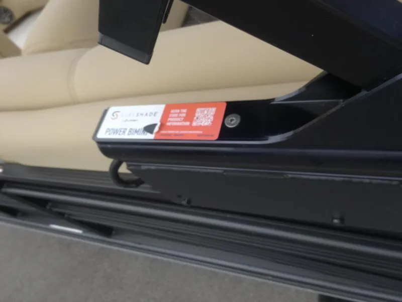 Slide: The Image of 2023 Harris Sunliner 230 boat detail, featuring a power bimini mechanism with beige seating. - 7