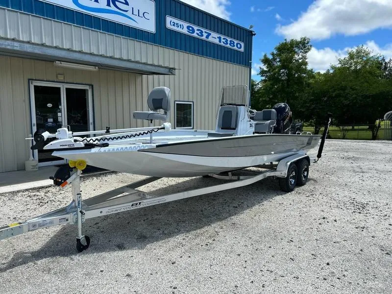 Slide: The Image of 2025 Xpress H22B boat on trailer outside dealership, clear sky background. - 1