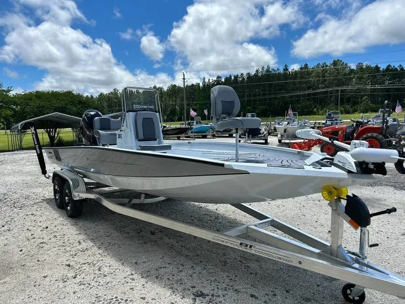 Slide: The Image of 2025 Xpress H22B boat on trailer, parked outdoors under a blue sky. - 4