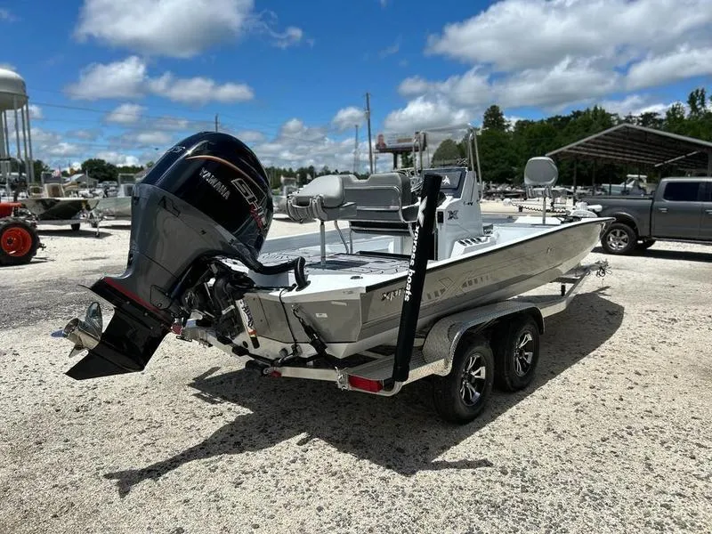 Slide: The Image of 2025 Xpress H22B boat with Yamaha outboard motor on trailer, parked outdoors. - 5