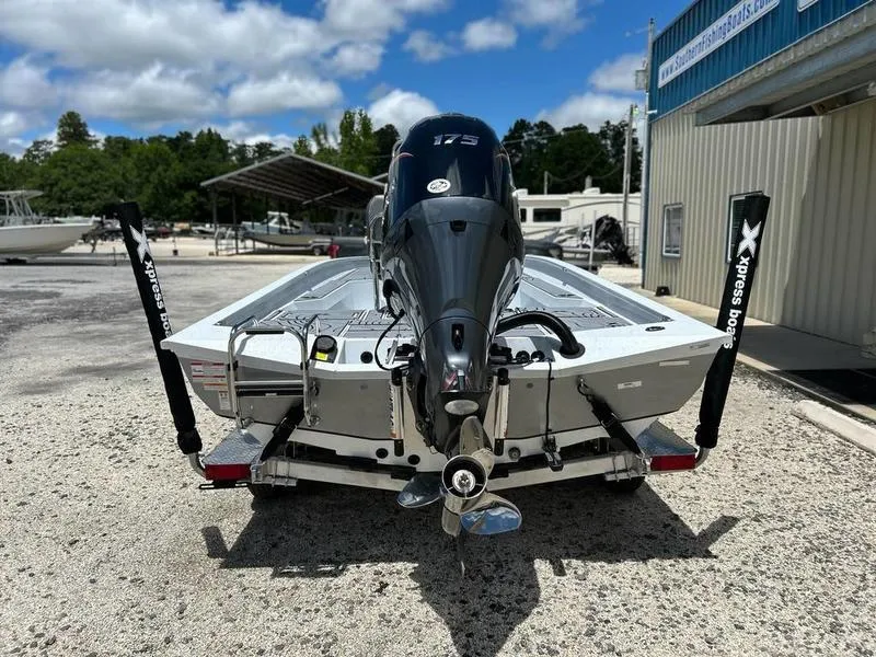 Slide: The Image of 2025 Xpress H22B boat with powerful outboard motor, parked outdoors on a sunny day. - 6