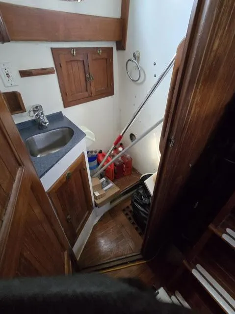 Slide: The Image of 1978 Formosa 46 yacht interior with wooden cabinetry and compact sink area. - 12