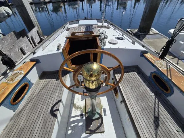 Slide: The Image of 1978 Formosa 46 sailboat cockpit with wooden wheel and brass compass, docked at marina. - 14