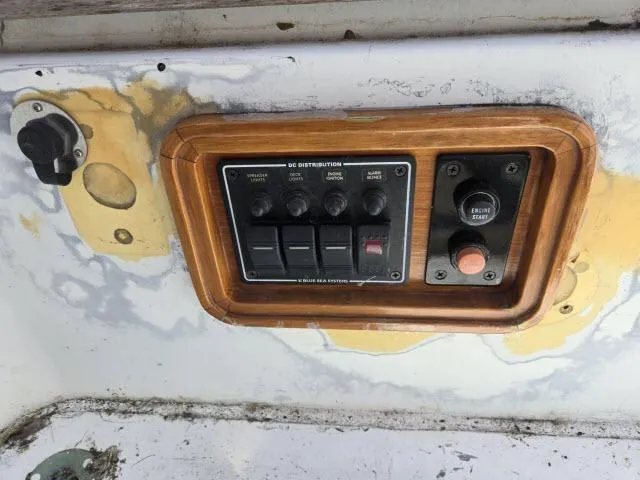 Slide: The Image of Control panel on a 1978 Formosa 46 boat with switches and weathered surface. - 18