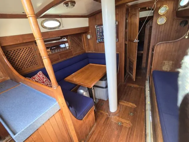 Slide: The Image of 1978 Formosa 46 yacht interior with wooden finish, blue seating, and dining area. - 2