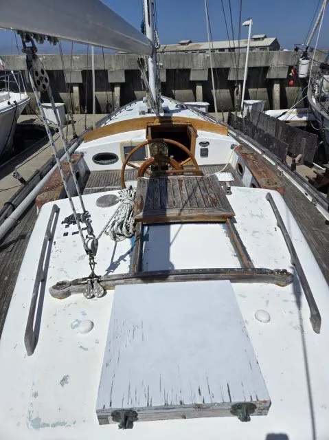 Slide: The Image of 1978 Formosa 46 sailboat deck with wooden accents and steering wheel in a marina. - 21