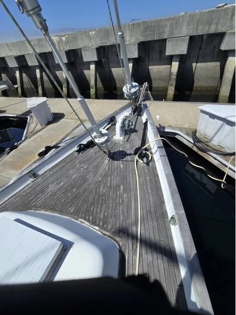Slide: The Image of 1978 Formosa 46 sailboat deck at dock, featuring wooden planks and rigging. - 23