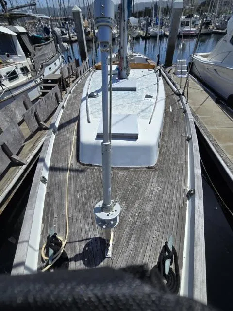 Slide: The Image of 1978 Formosa 46 sailboat docked, showcasing wooden deck and mast in marina setting. - 24