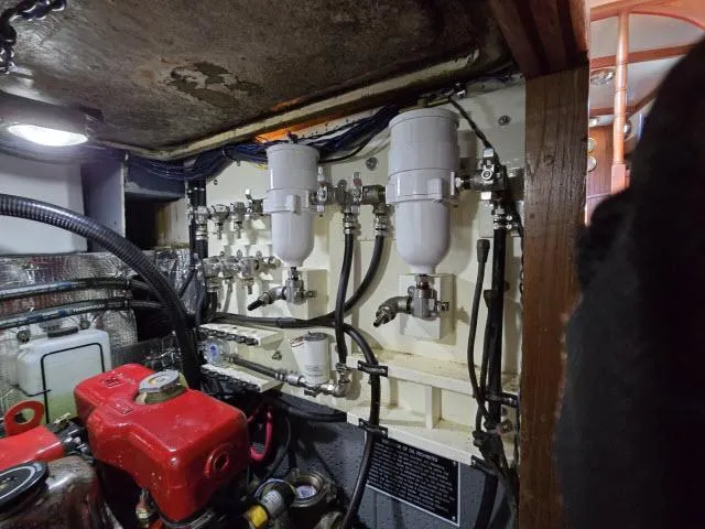 Slide: The Image of Engine room of a 1978 Formosa 46 sailboat, featuring fuel filters and mechanical components. - 29