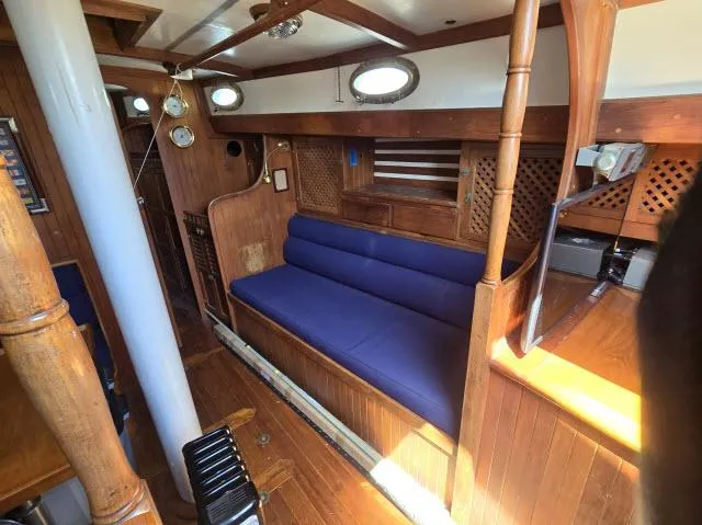 Slide: The Image of 1978 Formosa 46 yacht interior with wooden finish and blue cushioned seating. - 3