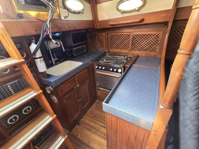 Slide: The Image of 1978 Formosa 46 yacht kitchen with wooden cabinetry, stove, and sink. - 4