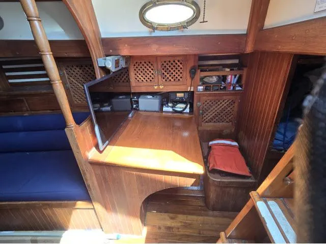 Slide: The Image of 1978 Formosa 46 yacht interior with wooden cabinetry, seating, and a small desk area. - 5