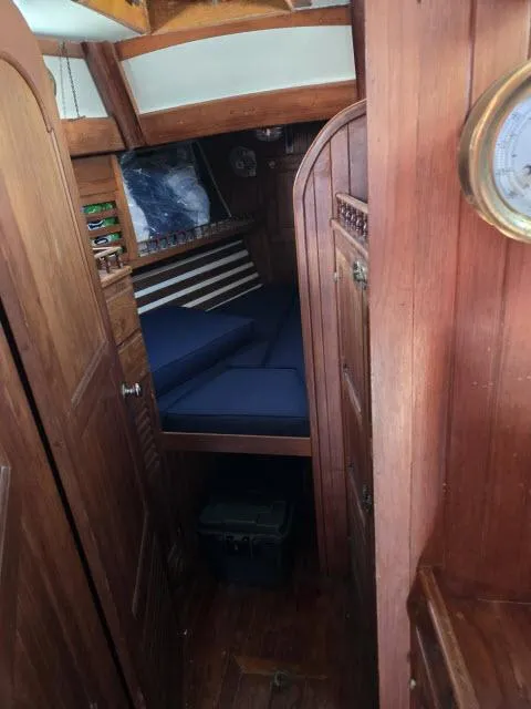 Slide: The Image of 1978 Formosa 46 yacht interior with wooden paneling and cozy sleeping area. - 7