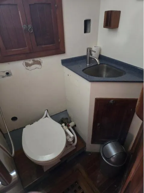 Slide: The Image of 1978 Formosa 46 yacht bathroom with sink, toilet, and wooden cabinetry. - 9