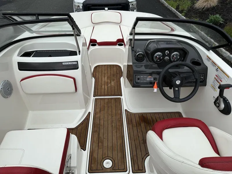 Slide: The Image of 2016 Bayliner VR5 Bowrider interior with wood accents and red-trimmed seating. - 10