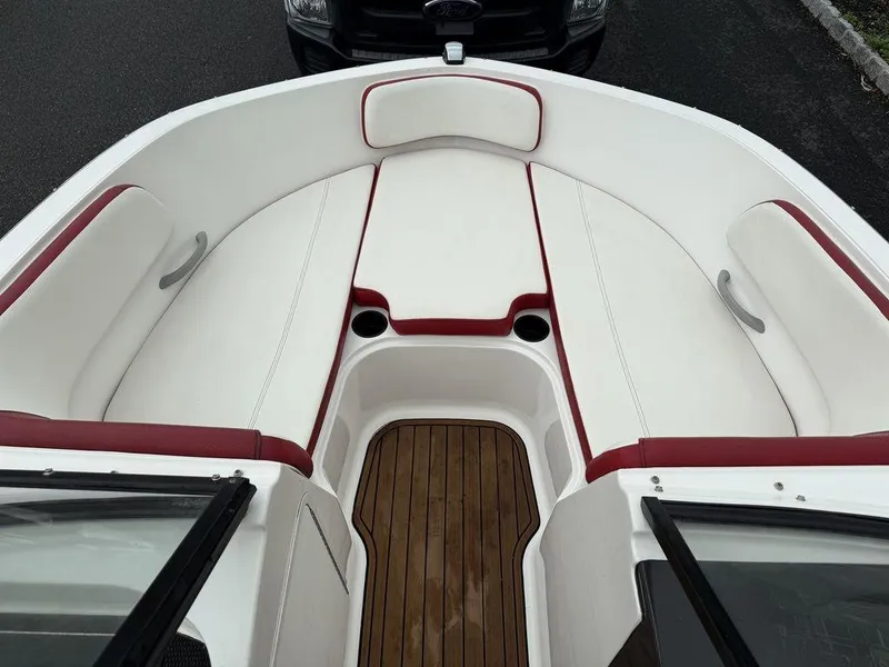 Slide: The Image of 2016 Bayliner VR5 Bowrider interior with white and red seating, wooden flooring. - 11