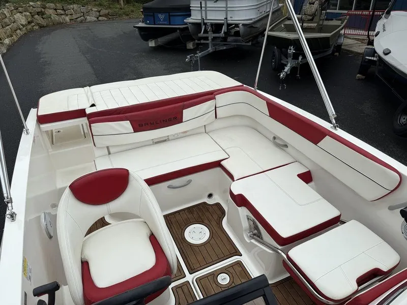 Slide: The Image of 2016 Bayliner VR5 Bowrider interior with red and white seating, wood flooring, and steering wheel. - 14