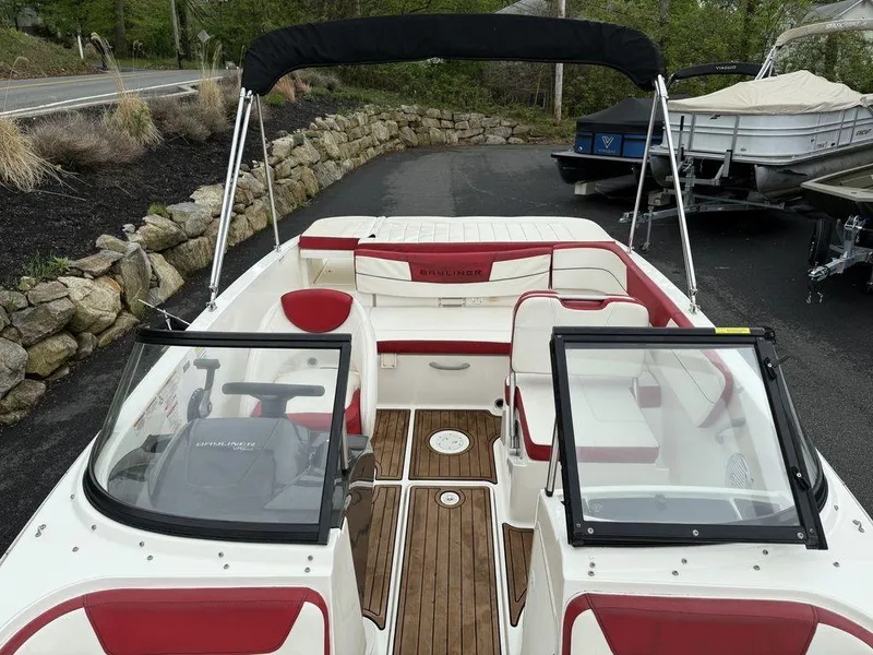 Slide: The Image of 2016 Bayliner VR5 Bowrider with red and white interior, docked on a paved area. - 16