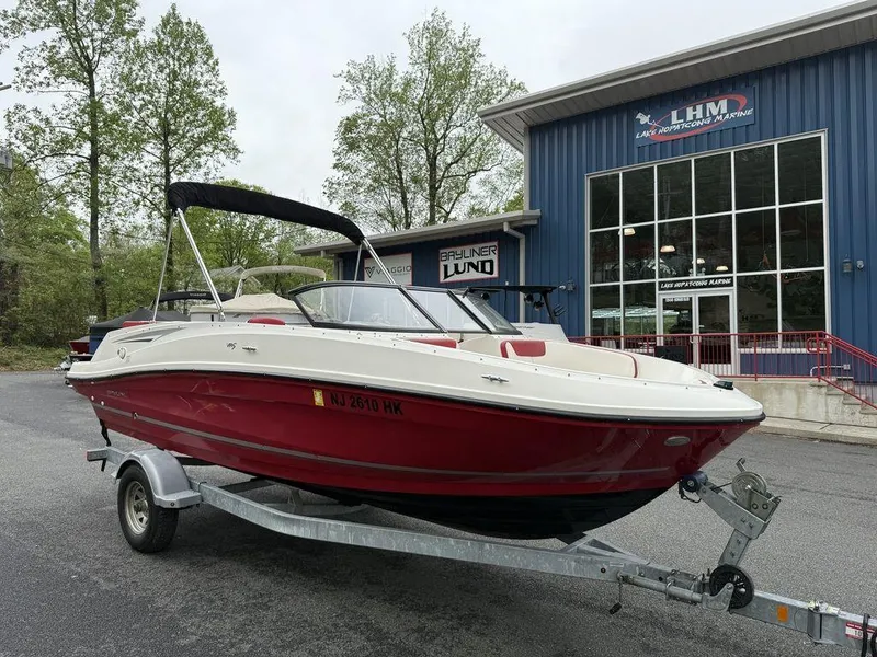 Slide: The Image of 2016 Bayliner VR5 Bowrider on trailer outside dealership, featuring red and white design. - 3