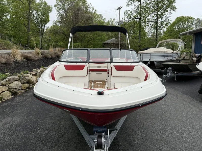 Slide: The Image of 2016 Bayliner VR5 Bowrider boat with red and white interior, parked on a trailer. - 6