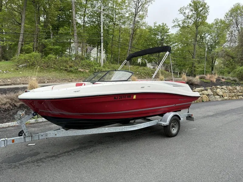 Slide: The Image of 2016 Bayliner VR5 Bowrider on trailer, red and white, parked on roadside. - 7