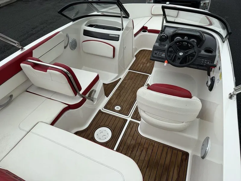 Slide: The Image of 2016 Bayliner VR5 Bowrider interior with red and white seating, wood flooring, and steering console. - 8